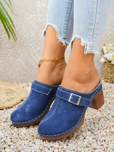 Dettaglio ravvicinato di sabot con tacco in camoscio blu con fibbia argentata regolabile