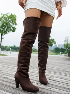 Detailed view of stylish brown suede over-the-knee boots featuring elegant high heels