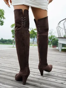 Back view of stylish brown suede over-the-knee high heel boots with lace-up detail