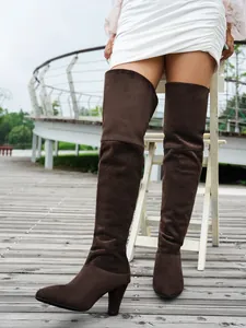 Close-up detail of dark brown suede pointed-toe over-the-knee boots with high heels