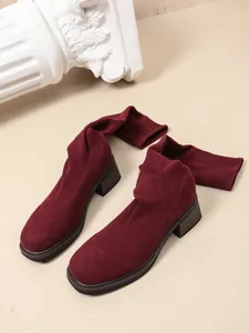 Detailed view of dark burgundy knit over-the-knee sock boots with a stable chunky block heel