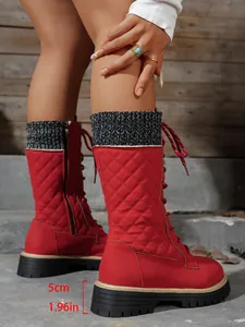 Vista dettagliata di stivali trapuntati rossi con suola platform da 5cm e bordo in maglia
