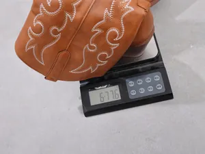 Mesure détaillée du poids d'une botte de cow-boy marron brodée pour femme sur une balance