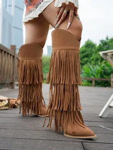 Brown faux suede high-tube boots featuring tiered fringe detailing and slim stiletto heels.