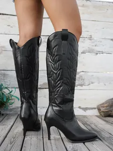 Side view of black pointed toe stiletto boots with elegant leaf embroidery details