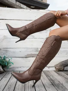 Detail view of brown embroidered knee-high boots with pointed toe and stiletto heel