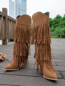 Side view of tall brown fringe boots with pointed toe and thin high heel design