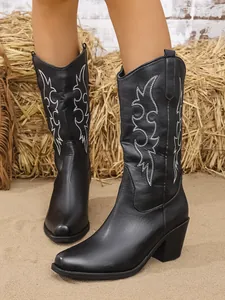 Détail rapproché de bottes de cowboy western en cuir noir avec broderie blanche