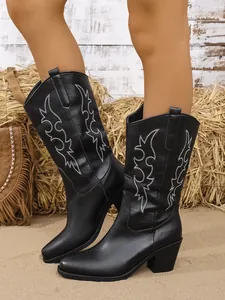 Gros plan de bottes de cowboy noires avec broderie blanche décorative et talon bloc