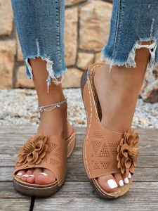Vue détaillée de sandales compensées marron avec une fleur 3D et un motif ajouré chic