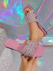 Close-up of pink fashion sandals featuring shimmering rhinestone geometric straps