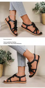 Detail of black Bohemian sandals featuring 3D floral accents and comfortable flat soles