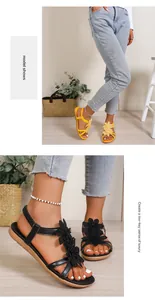 Detailed view of bohemian flat sandals with elegant flower decorations in yellow and black