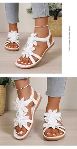 Detailed view of white Bohemian flat sandals with floral accents and elastic straps