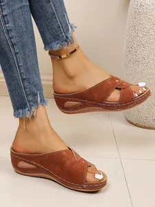 Close-up of brown platform wedge sandals with white contrast stitching and peep-toe design