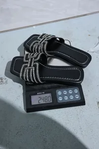 Weight measurement showing black rhinestone flat sandals at 248 grams on scale