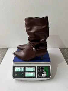 Detailed macro shot of dark brown pointed toe stiletto boot weight on a digital scale