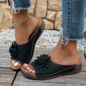 Élégantes sandales compensées noires pour femmes avec détail de fleur et design ajouré