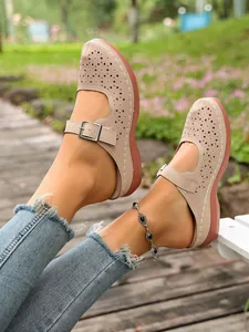 Close-up view of elegant women's beige cutout wedge mules featuring adjustable buckle straps