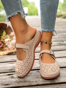 Detailed view of beige hollow-out wedge slippers with an adjustable buckle strap.