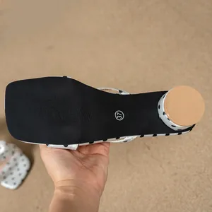 Detailed view showing the black sole and size 37 label of a polka dot block heel sandal