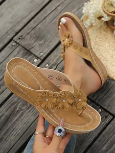 Detailansicht der modischen Damen-Keilsandalen mit Retro-Blumendekor und weißen Ziernähten.