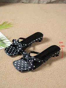 Detailed view of French style polka dot bow slide sandals with a 3cm low chunky heel