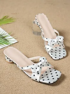 Detailed view of French-style polka dot bow slide sandals with square toe and block heel