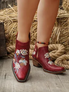 Detalle de primer plano de botines occidentales granates con bordado floral vintage