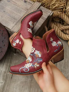 Detalles de bordado floral y recortes laterales en botines bordeaux de estilo western