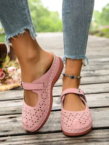Detail view of pink laser-cut Mary Jane platform mules with adjustable buckle strap.
