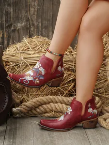 Botines occidentales rojos vintage con elegantes bordados florales y tacón medio.