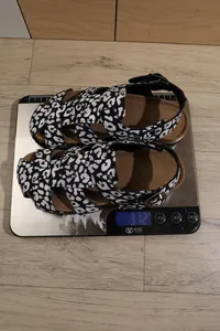 Detailansicht des Gewichts von 372 g für Leoparden-Plateausandalen auf einer Waage