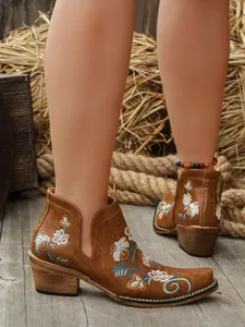 Elegantes botines western marrones con bordados florales y tacón de bloque alto.