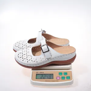 Macro view showing the weight of white hollow-out platform mule sandals on a scale