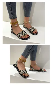 Zebra print flat sandals featuring stylish pearl and gold chain ankle straps
