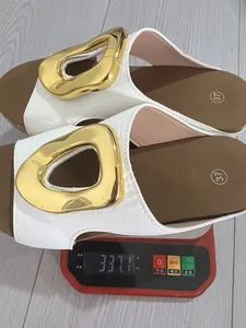 Close-up detail view of white wedge sandals with gold buckle showing product weight of 337.1g