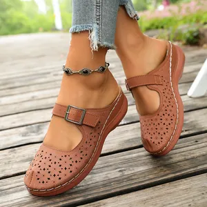Detailed close-up of women's tan hollow-out wedge sandals featuring a buckle strap