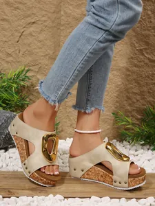 Detailed view of stylish women's wedge sandals with gold buckle and rivet accents