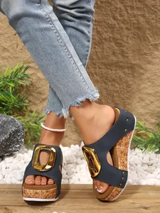 Macro view of navy blue platform wedge sandals with golden buckle detail on cork sole