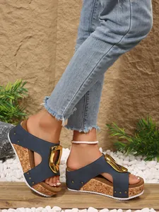 Detail of blue wedge sandals with gold buckle and rivet accents for women