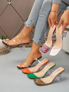 Detailed view of square toe sandals with transparent straps and clear wine glass heels