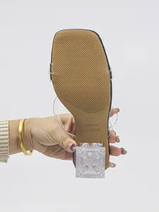 Detailed macro view of clear square toe high heel sandals showing anti-slip brown sole