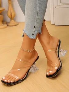 Detailed view of women's stylish transparent high heel sandals with clear sculptural heel