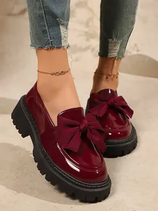 Detailansicht weinroter Lackleder-Loafer mit großer Schleife und modischer, dicker Profilsohle
