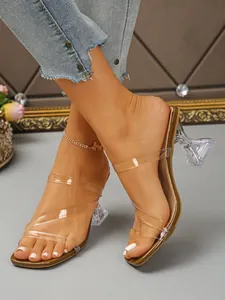 Macro view of transparent high heel sandals with unique sculptural glass-like heel.