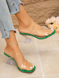 Chic square toe sandals featuring clear PVC straps and a green footbed on sculptural heels