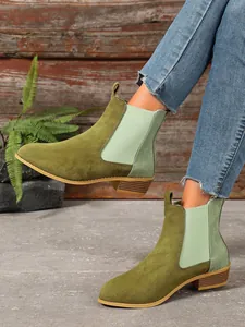 Detailed view of olive green vintage Chelsea boots with square heel and croc texture.