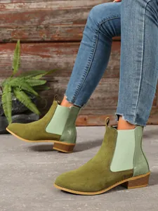 Detail view of green suede Chelsea boots with square block heel and side elastic band