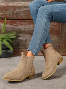 Khaki suede Chelsea boots with comfortable block heel for women in vintage style on feet